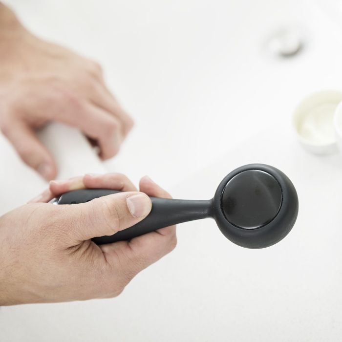 Čovjek drži u ruci PMD Clean Pro Ob uređaj za čišćenje lica